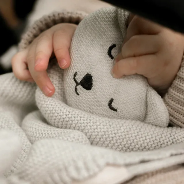 Baby knit comforter available in oat and sage, made from organic cotton.