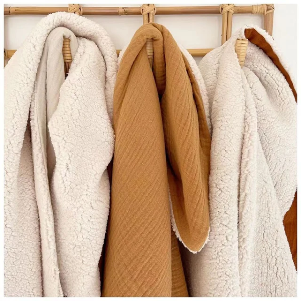 Baby snuggled in a cozy organic sherpa blankie for warmth and comfort.